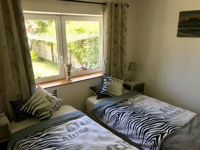 two beds in a room with a window at African Holiday home in Table View in Cape Town