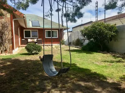 a swing in the yard of a house at African Holiday home in Table View in Cape Town