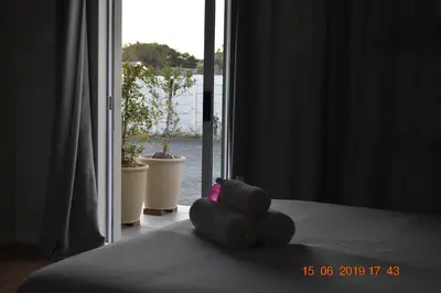 a teddy bear sitting on a bed in a room at Pringle Nest in Cape Town