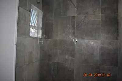 a bathroom with a shower with a window at Pringle Nest in Cape Town
