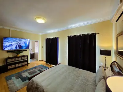a bedroom with a bed and a flat screen tv at Walters Lane Luxury Accommodation main house - No loadshedding in Cape Town