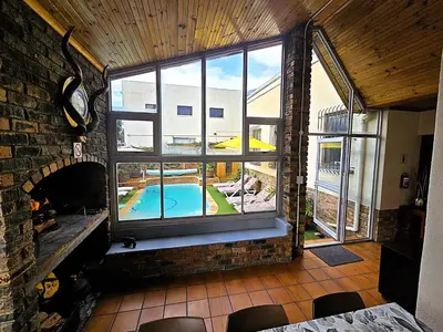 a room with a large window with a swimming pool outside at Walters Lane Luxury Accommodation main house - No loadshedding in Cape Town