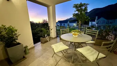 a table and chairs on a balcony with a view at The Lemon Tree in Franschhoek in Franschhoek