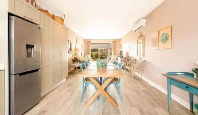 a kitchen and dining room with a table and a refrigerator at The Lemon Tree in Franschhoek in Franschhoek