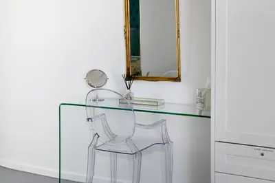 a glass table with two chairs and a mirror at No. 6 The Yard in Franschhoek