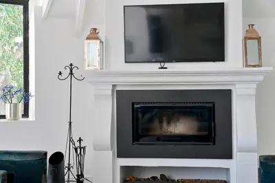 a fireplace with a flat screen tv on top of it at No. 6 The Yard in Franschhoek