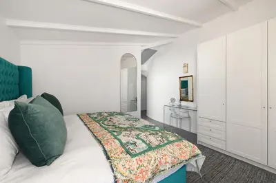 a white bedroom with a bed and a white cabinet at No. 6 The Yard in Franschhoek
