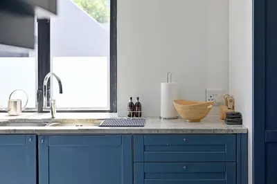 a kitchen with blue cabinets and a sink at No. 6 The Yard in Franschhoek