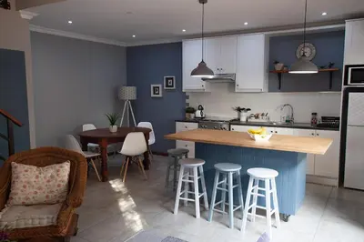 a kitchen with a counter and a table and chairs at Culemborg Cottage in Cape Town
