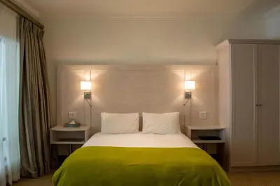 a bedroom with a large bed with two lamps at Val Du Charron Wine & Leisure Estate in Wellington