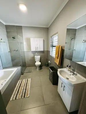 a bathroom with a tub and a toilet and a sink at Nemesia Court in Durbanville