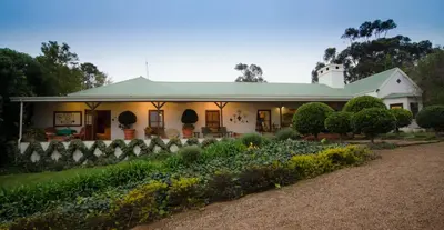 a house with a garden in front of it at Rouxwil Country House in Caledon