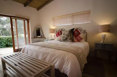 a bedroom with a bed with a bench in it at Rouxwil Country House in Caledon