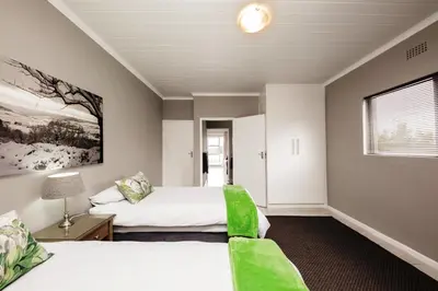 a bedroom with two beds and a window at Villa Eike in Grabouw