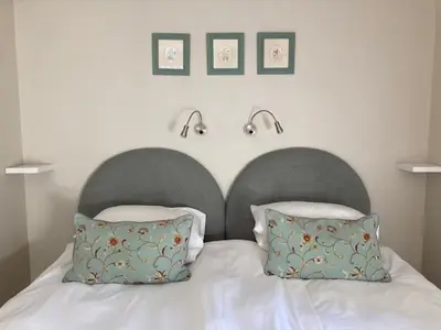 a bed with two pillows and two lights above it at Maroela House Guest Accommodation in Bellville