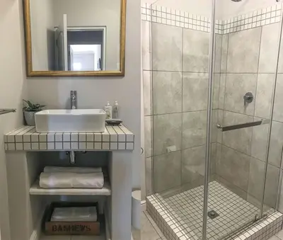 a bathroom with a sink and a shower at Lavender Suite in Cape Town