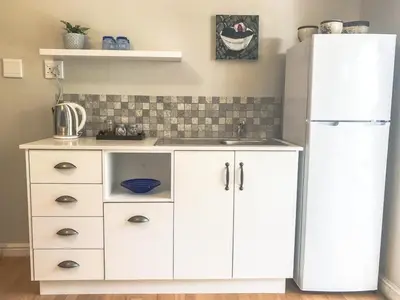 a kitchen with a white refrigerator and a sink at Lavender Suite in Cape Town