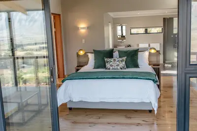 a bedroom with a bed with green pillows at Opstal Stay in Rawsonville
