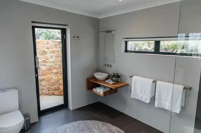 a bathroom with a glass shower and a toilet at Opstal Stay in Rawsonville