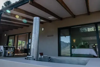 a house with a room with a bed and windows at Opstal Stay in Rawsonville