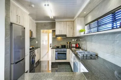 a kitchen with a sink and a dishwasher at 9a@Crassula Way in Cape Town