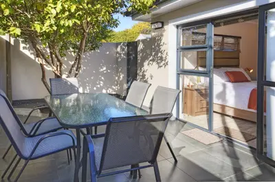 a patio with a table and chairs and a bedroom at 9a@Crassula Way in Cape Town