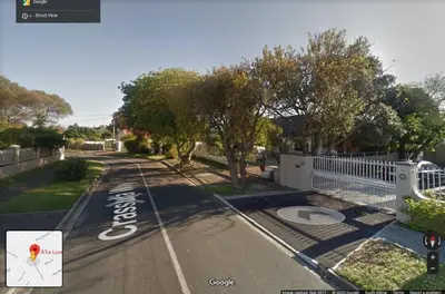 an empty street with trees and a white fence at 9a@Crassula Way in Cape Town