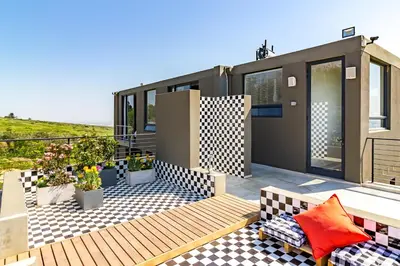 a house with a deck with a view at Stellar Guest Villa on Stunning Wine Farm in Cape Town