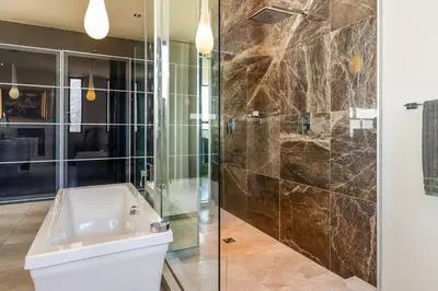 a bathroom with a toilet and a glass shower at Stellar Guest Villa on Stunning Wine Farm in Cape Town