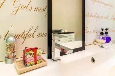 a bathroom with a mirror and a gift on a sink at Stellar Guest Villa on Stunning Wine Farm in Cape Town