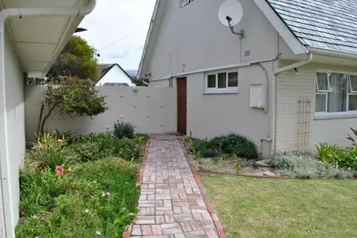 a brick path in front of a white house at Cotswold House Residence in Cape Town