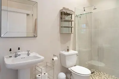 a bathroom with a toilet and a sink and a shower at Sandown Lodge in Cape Town