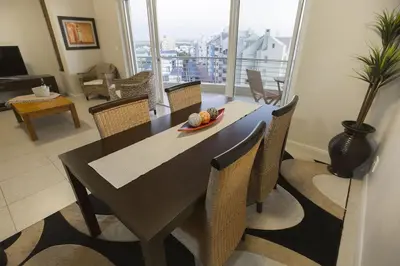 a dining table and chairs in a living room at 2 Bedroom apartment with Breathtaking Views! in Cape Town