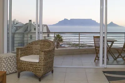 a room with a balcony with a table and a chair at 2 Bedroom apartment with Breathtaking Views! in Cape Town