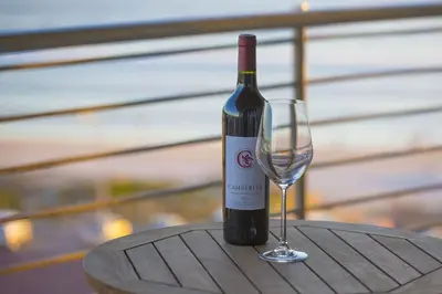a bottle of wine and a wine glass on a table at 2 Bedroom apartment with Breathtaking Views! in Cape Town