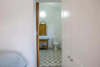 a bathroom with a sink and a toilet and a mirror at Denneboom Vineyards and Wildlife in Paarl