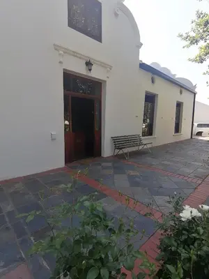 a building with a door and a bench in front of it at Le Arc Manor House in Franschhoek