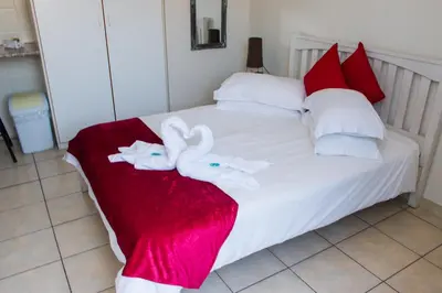 a bedroom with a bed with towels on it at Helderzicht Self-Catering in Brackenfell