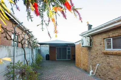a brick building with a gate and a patio at Helderzicht Self-Catering in Brackenfell