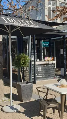 a table and a bench and an umbrella on a sidewalk at Franschhoek Studio in Franschhoek