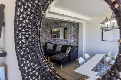 a mirror reflecting a living room with a couch and a table at 67 Whale Rock Estate, Hermanus in Hermanus
