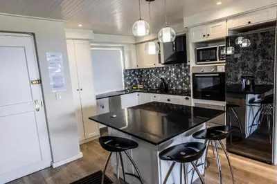 a kitchen with a black counter top and bar stools at 67 Whale Rock Estate, Hermanus in Hermanus