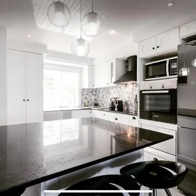 a kitchen with white cabinets and a black counter top at 67 Whale Rock Estate, Hermanus in Hermanus