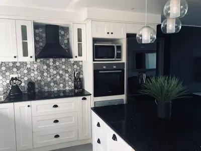 a kitchen with white cabinets and a black counter top at 67 Whale Rock Estate, Hermanus in Hermanus