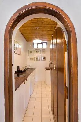 a hallway with an archway in a kitchen at Bartinney Private Cellar Banhoek in Stellenbosch