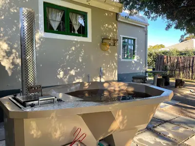 a large bath tub sitting in a yard at Kleine Vrede Farm Cottage in Hermanus