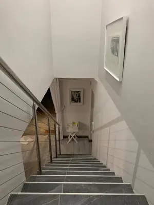 a staircase leading up to a room with a table at Bem Vindo Self Catering Guest House in Hermanus