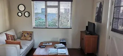 a living room with a couch and a coffee table at Jasmine Cottage - Fast Wi-Fi, slow living in Hermanus