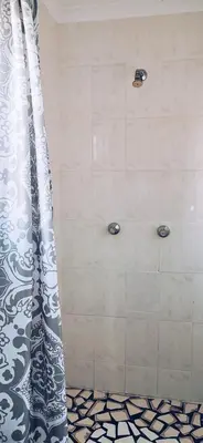 a shower with a black and white shower curtain at Jasmine Cottage - Fast Wi-Fi, slow living in Hermanus