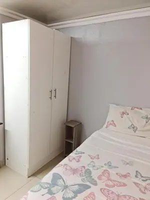 a white bedroom with a bed and a closet at Hasate Guest House 10 Florence street Oakdale Belliville 7530 cape town south African in Cape Town